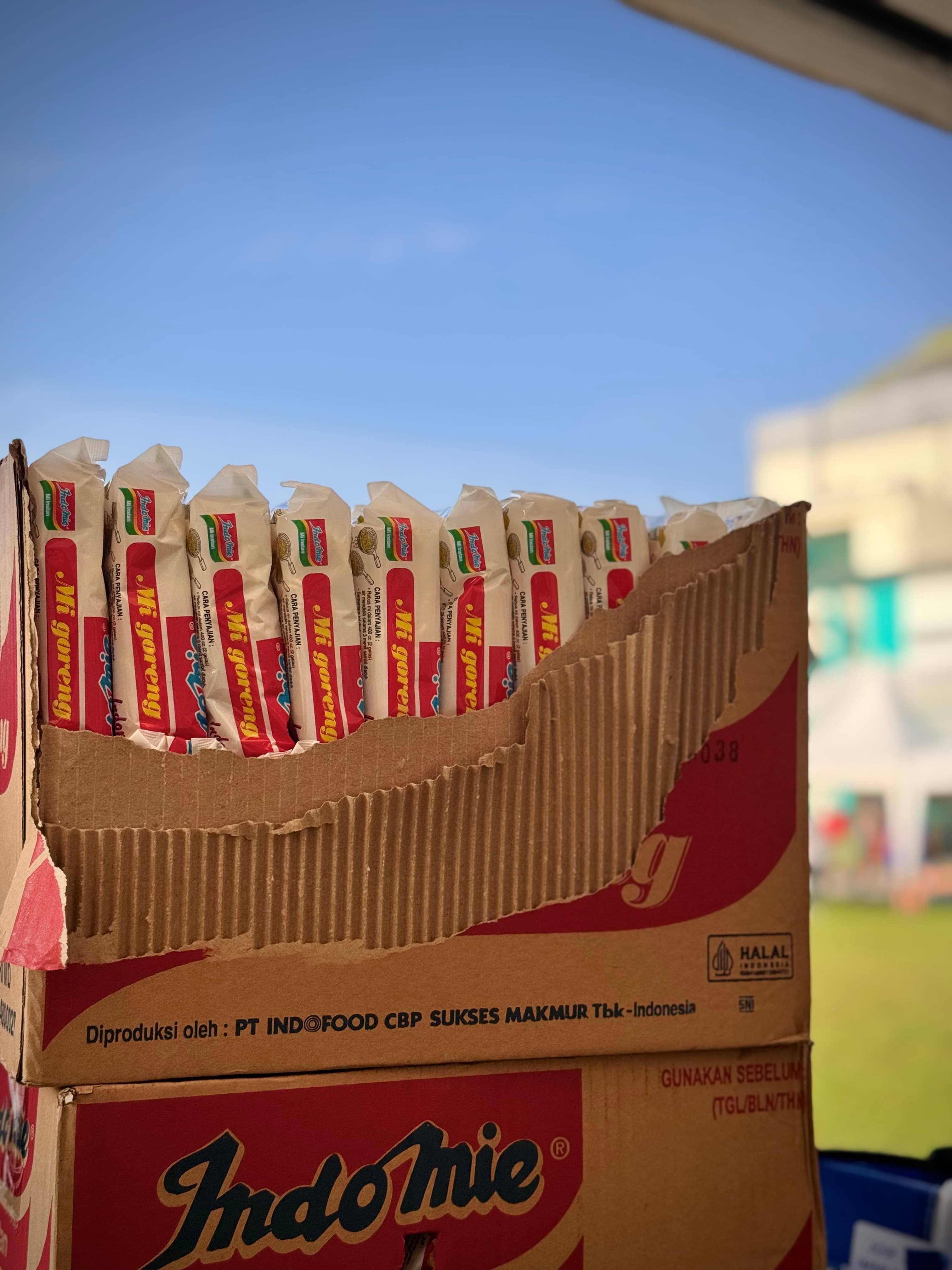 A carton of Indomie Mi Goreng Instant Noodles, to be cooked & sold with Warkop Dedicated's special recipe sauces and toppings.